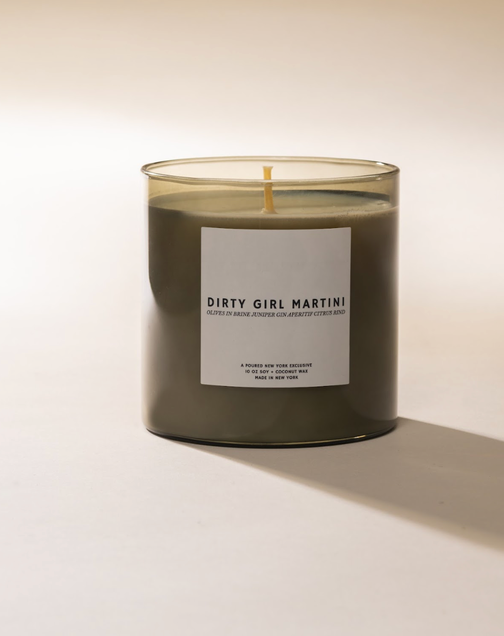Candle in clear glass jar labeled 'Dirty Girl Martini'.