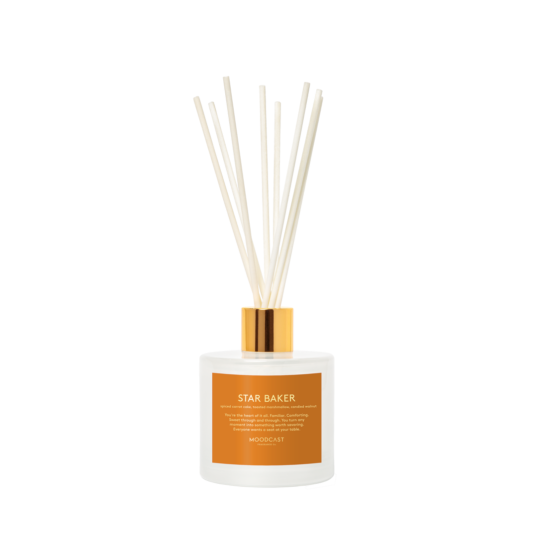 White diffuser jar  with white diffuser rods and gold cap with text 'Star Baker' on the label.