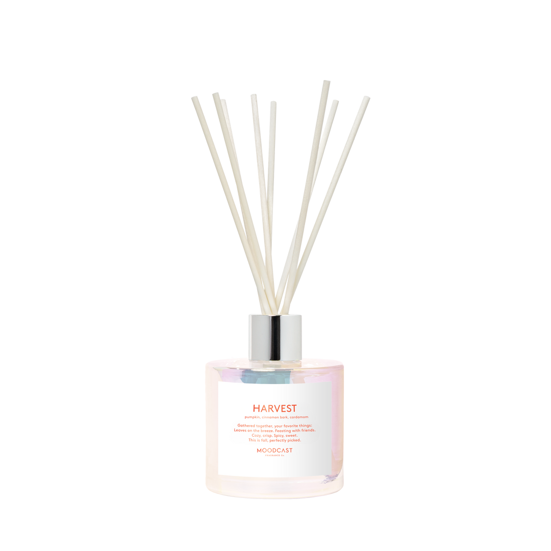 Pearlescent diffuser bottle with silver cap and diffuser rods. The text 'Harvest' is printed n the label.