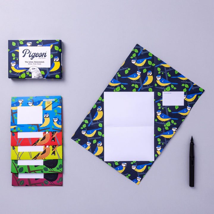 Writing set opened to show five envelopes, each with a different design, and the sixth unfolded to show the writing area, all decorated with bright birds.
