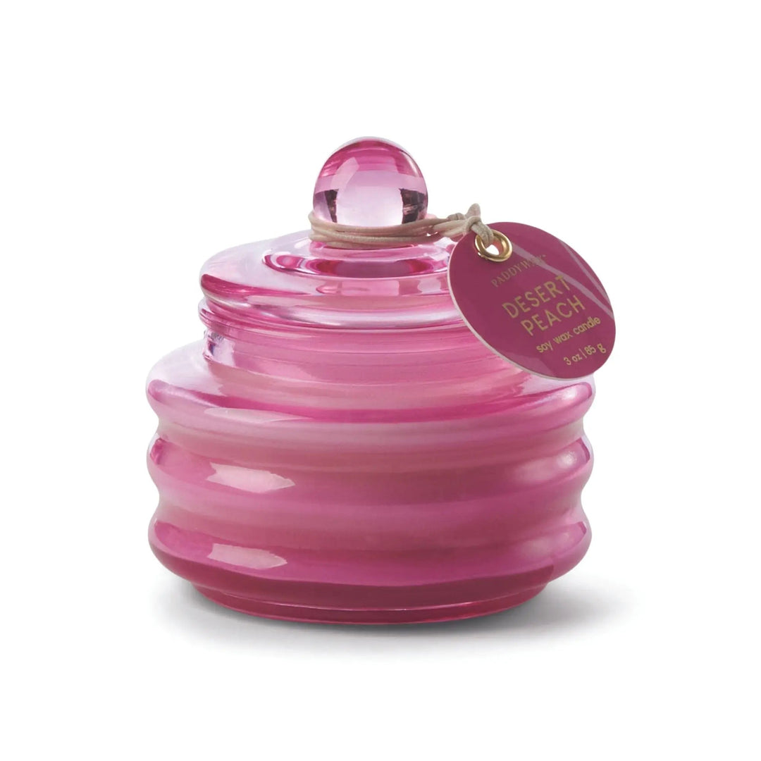 Translucent lidded glass jar with stylish round tag on a string in bright pink.