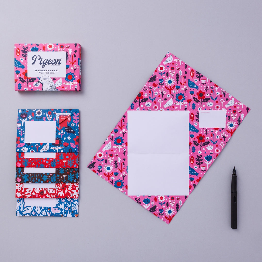 Writing set opened to show five envelopes, each with a different design, and the sixth unfolded to show the writing area, all decorated with bright flowers.