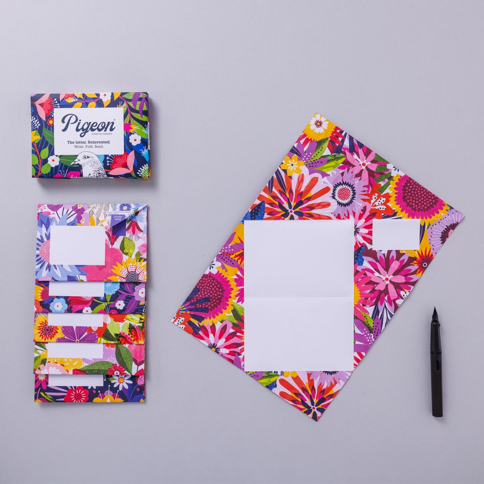 Writing set opened to show five envelopes, each with a different design, and the sixth unfolded to show the writing area, all decorated with bright flowers.