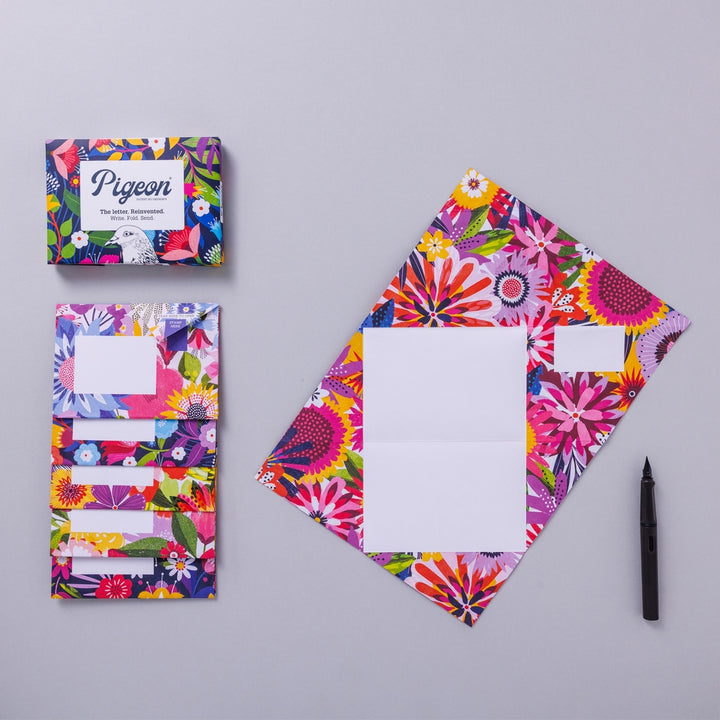 Writing set opened to show five envelopes, each with a different design, and the sixth unfolded to show the writing area, all decorated with bright flowers.