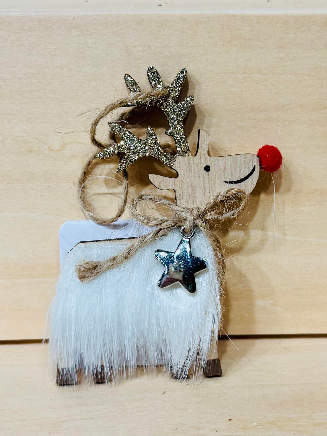 Decorative reindeer ornament with white fur, brown antlers, and a red nose.