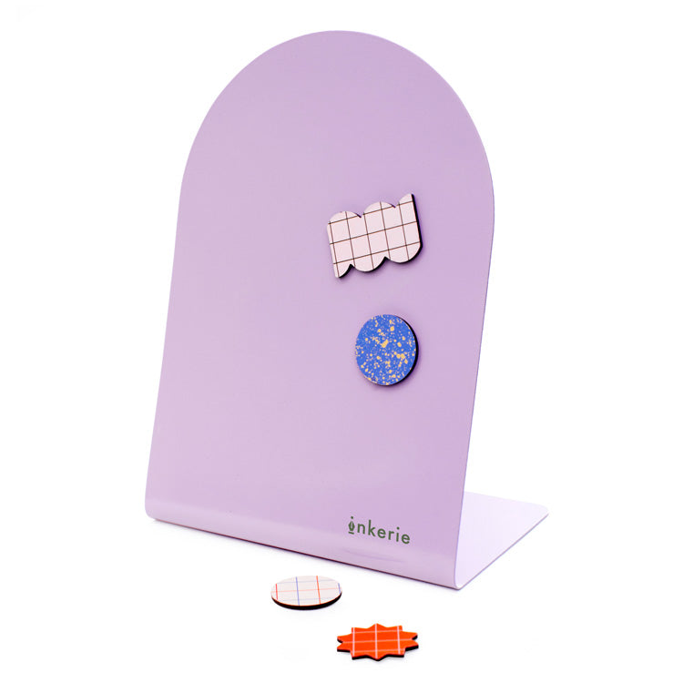 Purple metallic message board with colorful fun-shaped magnets.
