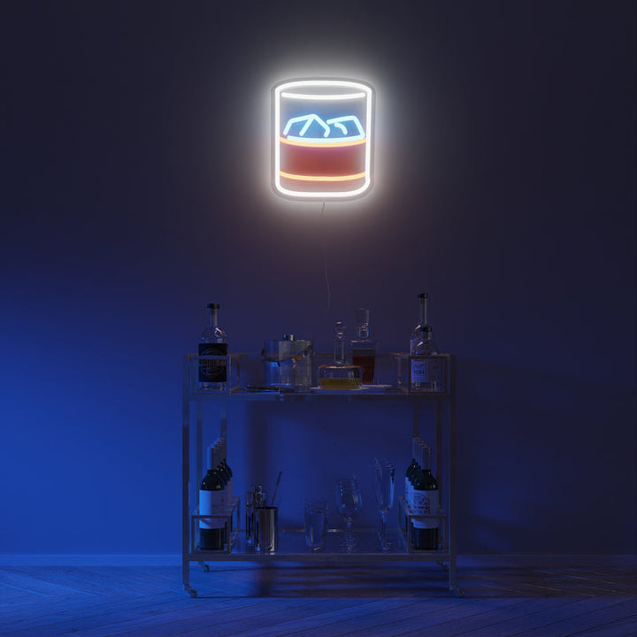 LED illuminated wall art depicting a rocks glass with ice cubes and brown liquor, hanging over bar