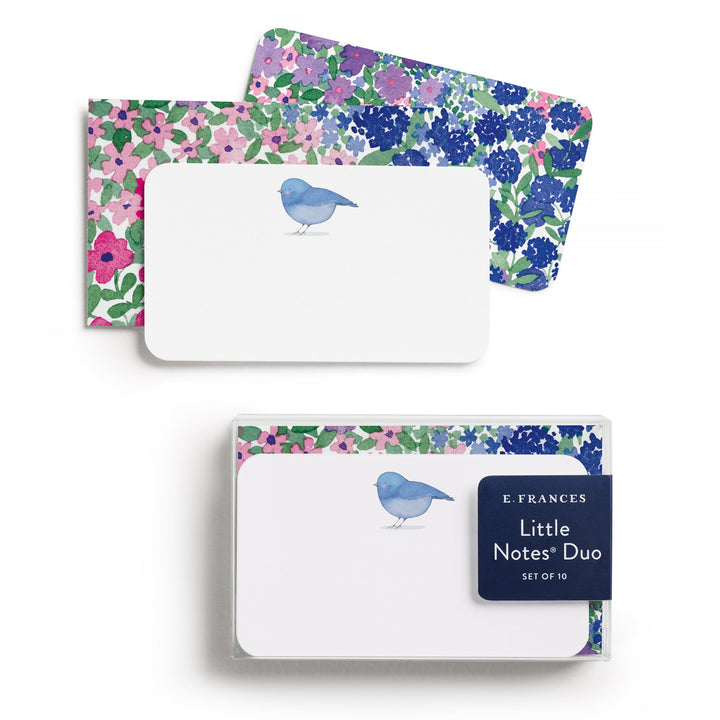 Little note with a blue bird at top center on top of an envelope covered with flowers. 
