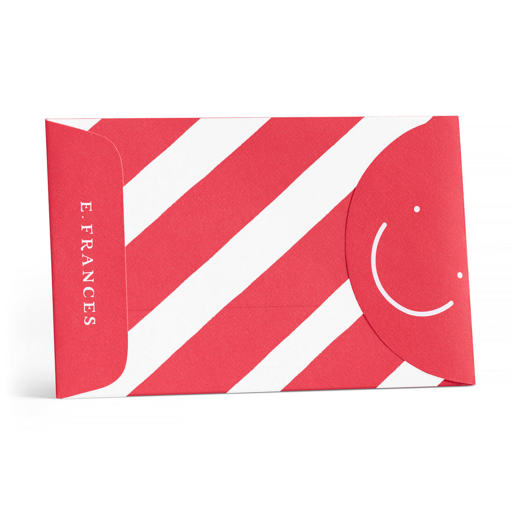 Red and white striped envelope with a smiley face on the flap.