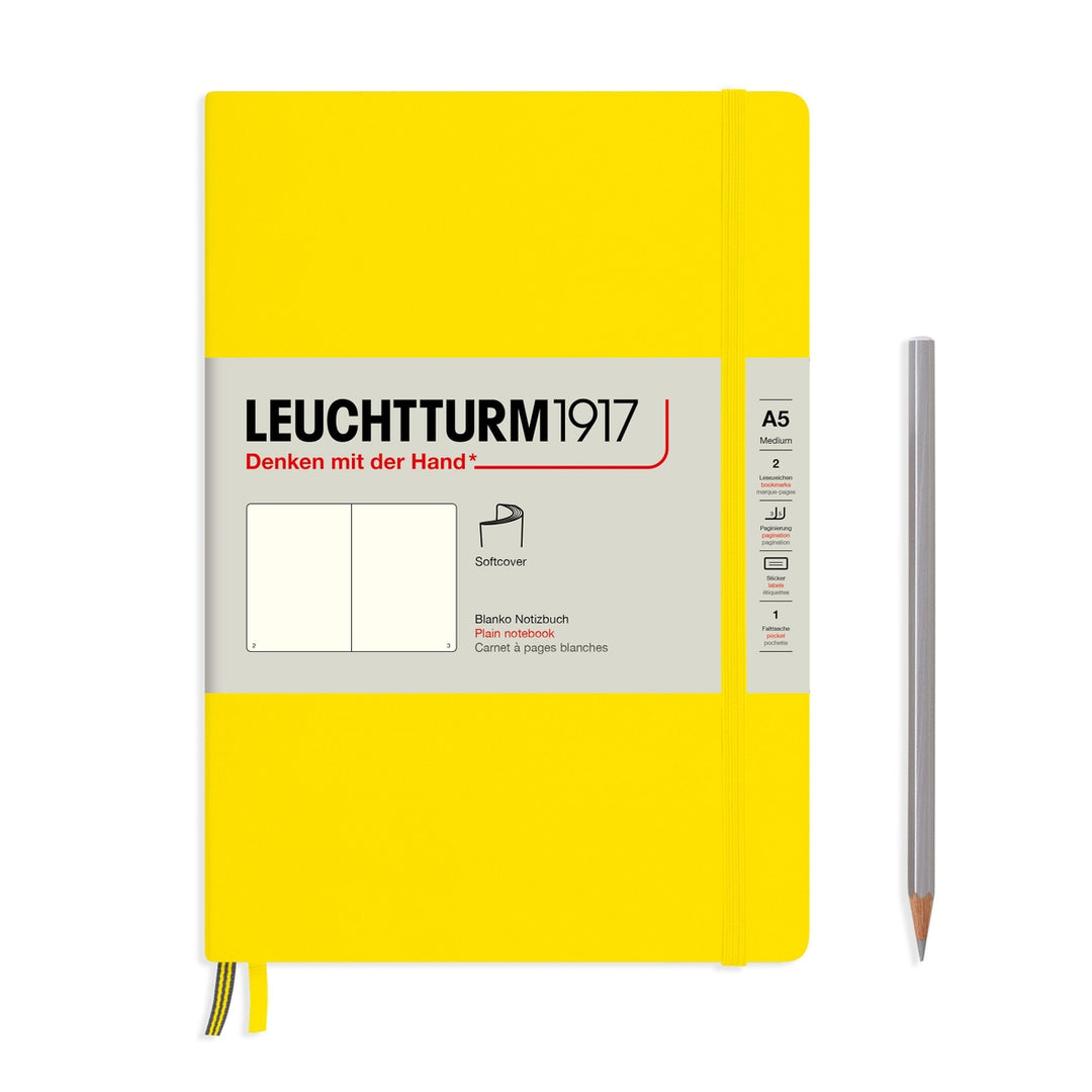 A lemon yellow Leuchtturm1917 A5 plain page pocket notebook with a white front label and yellow elastic closure,  next to a gray pencil.