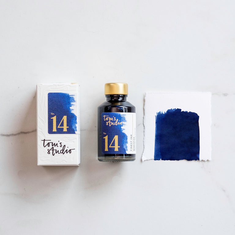 The box of Tom's Studio 04 Marianas Ink next to its bottle and a paint swatch.