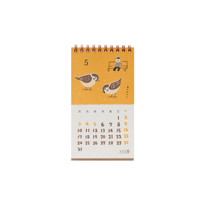 Calendar page for May with an illustration of two birds pecking at seeds and a man on a bench on a mustard-colored background.
