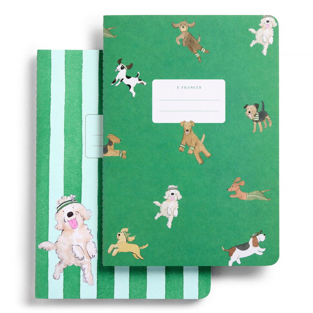 Two green notebooks illustrations of leaping dogs of various breeds, one on a solid green background and the other with stripes.