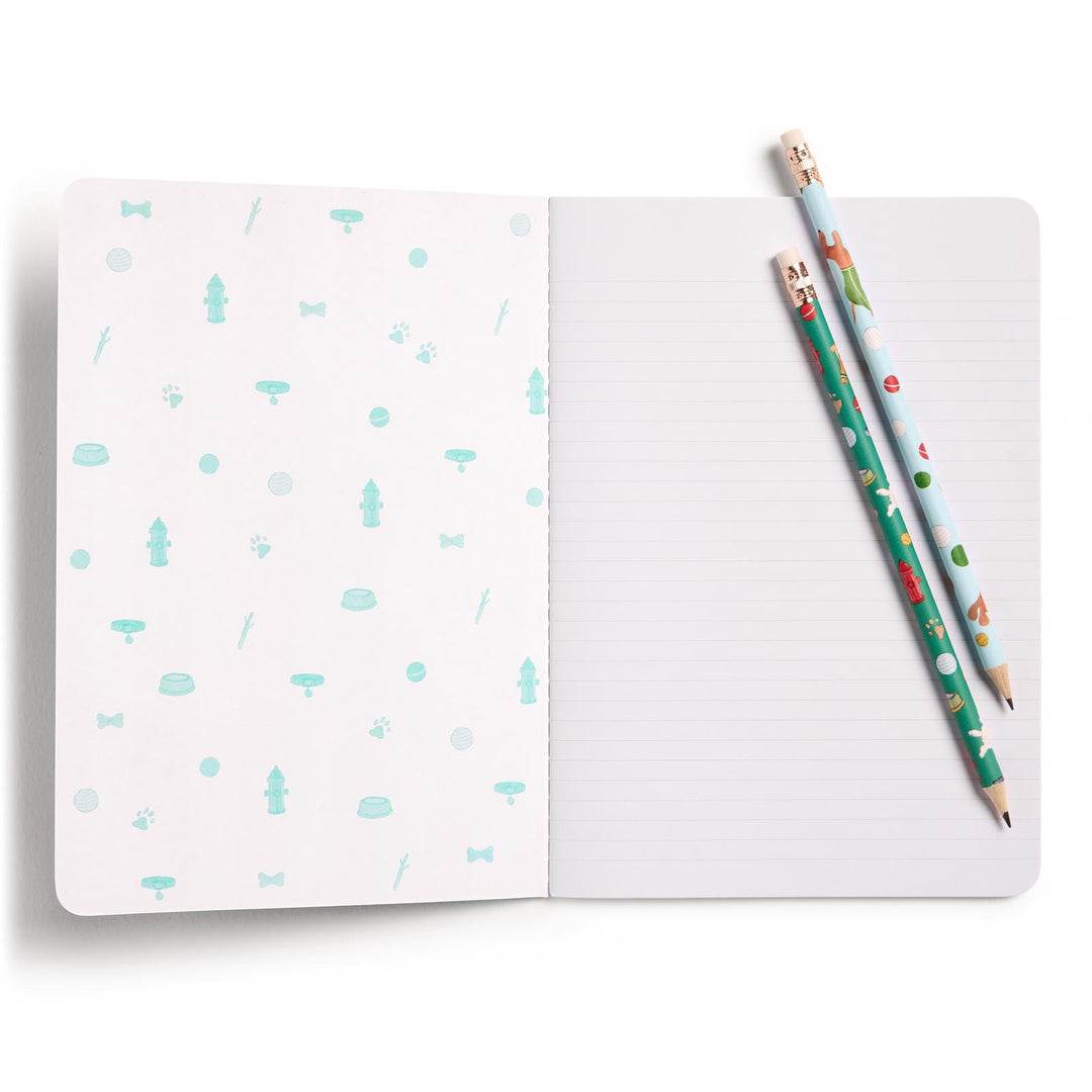 Open notebook with a patterned inside front cover and two pencils placed on a lined page.