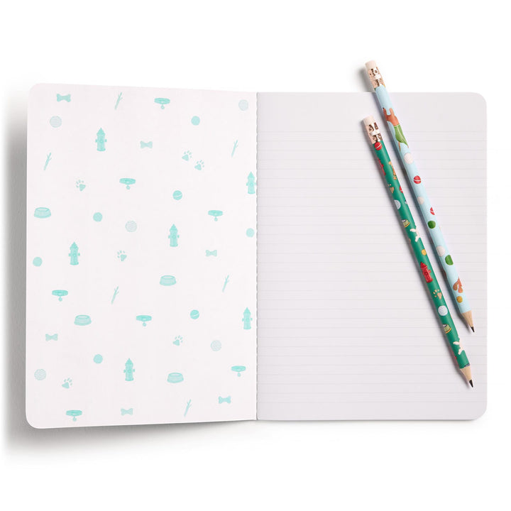 Open notebook with a patterned inside front cover and two pencils placed on a lined page.