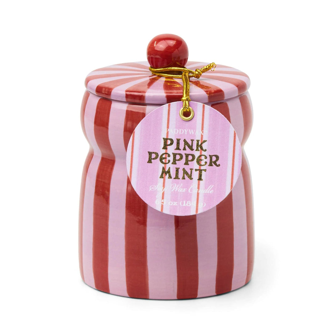 Ceramic candle holder with red and pink vertical stripes, with a round tag on a gold cord.