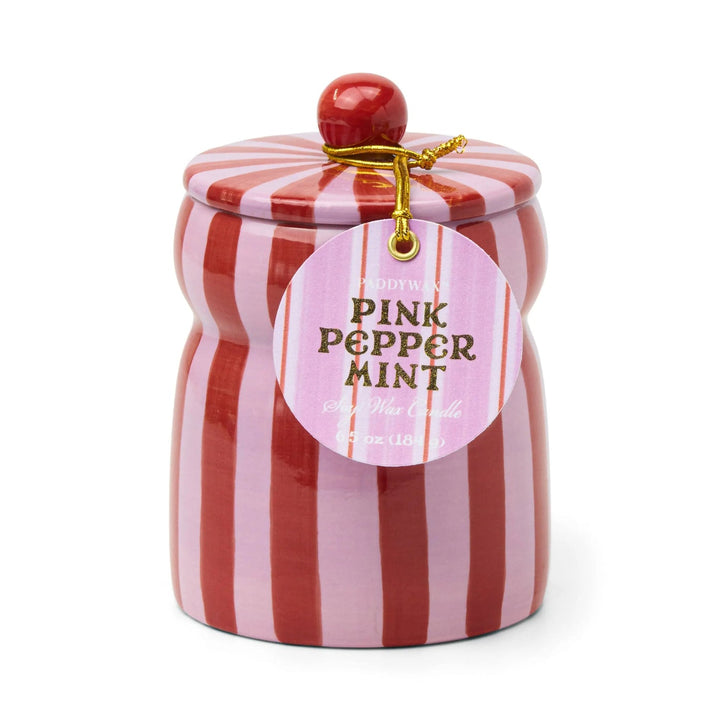 Ceramic candle holder with red and pink vertical stripes, with a round tag on a gold cord.