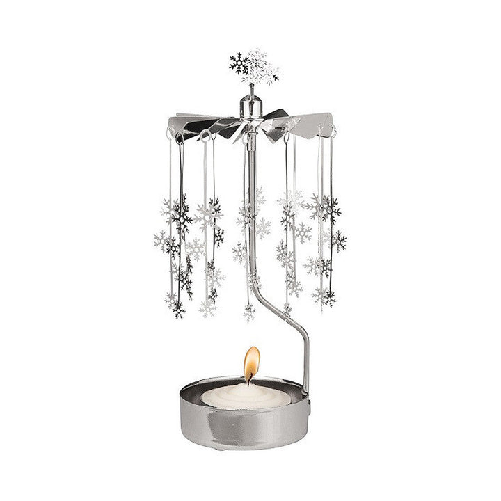 Tea light in a silver holder with vertical arm supporting a carousel of snowflakes.
