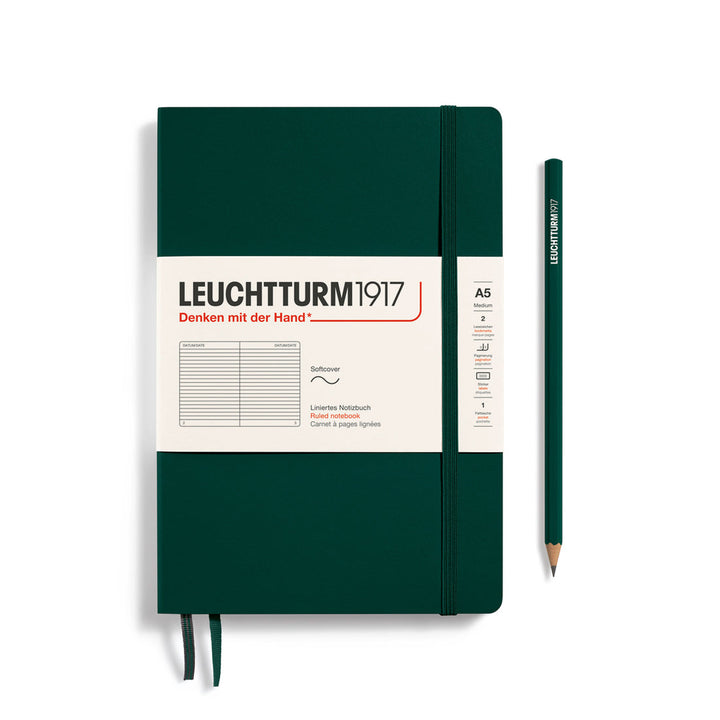Leuchtturm1917 soft cover ruled page notebook in forest green with white label and elastic closure, next to a forest green Leuchtturm1917 pencil.