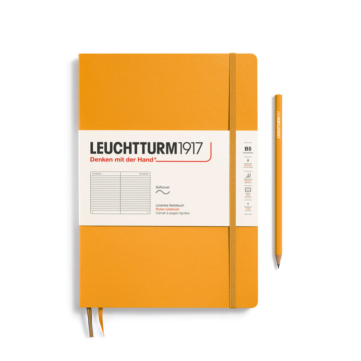 Leuchtturm1917 soft cover ruled page notebook in rising sun orange with white label and elastic closure, next to an orange Leuchtturm1917 pencil.