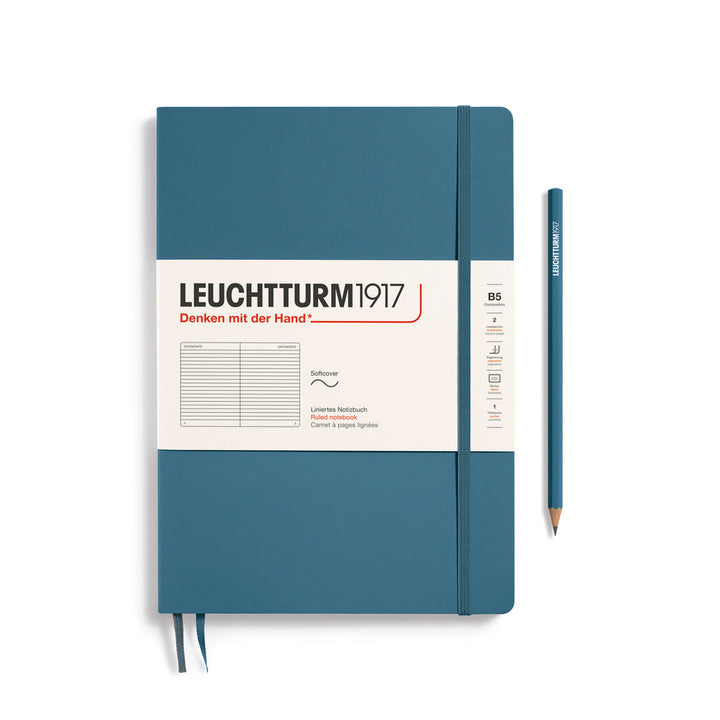 Leuchtturm1917 soft cover ruled page notebook in stone blue with white label and elastic closure, next to a stone blue Leuchtturm1917 pencil.