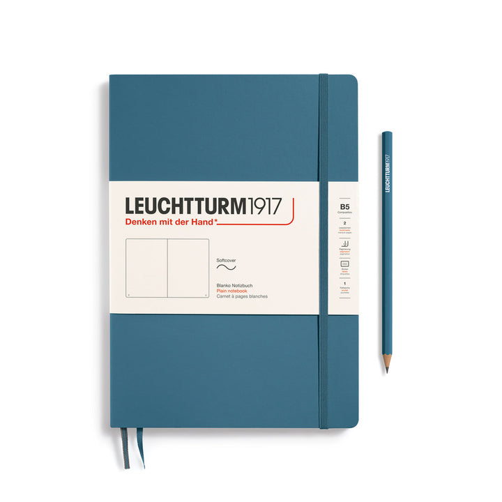 Leuchtturm1917 soft cover plain page notebook in stone blue with white label and elastic closure, next to a stone blue Leuchtturm1917 pencil.
