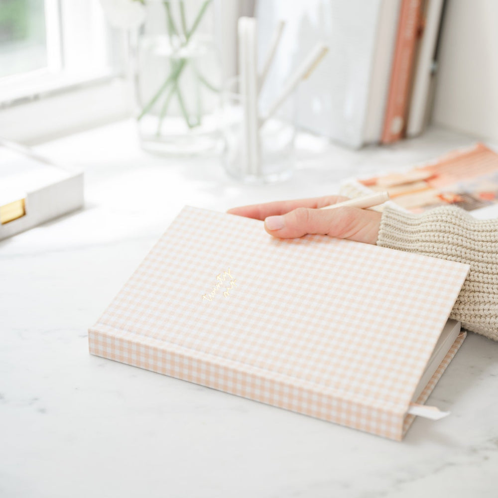 Person's hand holding the notebook showing the sturdy spine.