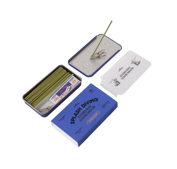 The blue container for 'Splash Diving' incense with the lid removed to show the incense sticks and clip. In the inverted lid is a stick inserted in the clip.