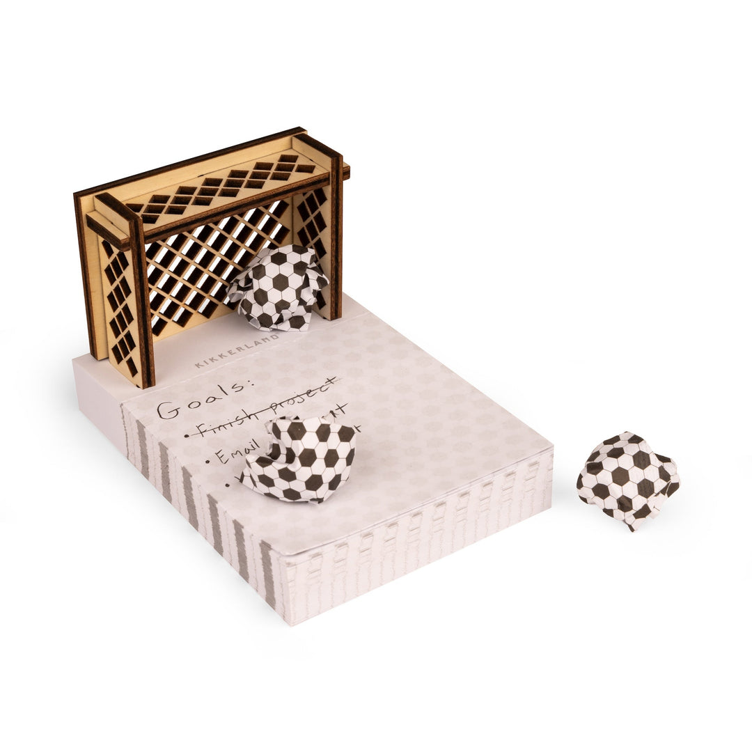 Sticky notes pad with assembled soccer goal and crumpled notes as soccer balls.