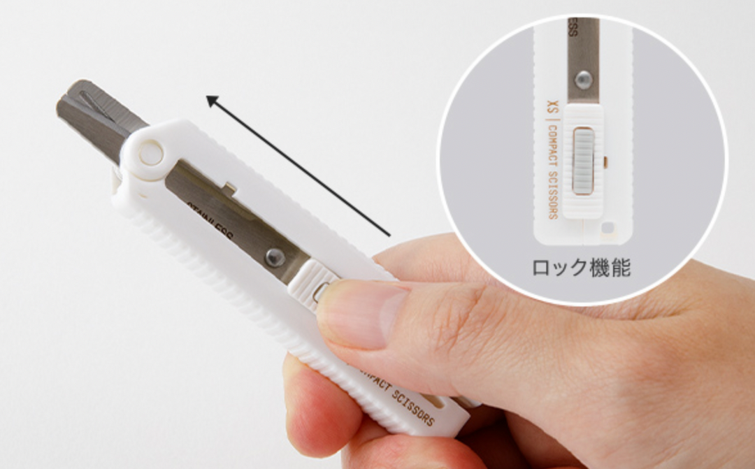 Hand with thumb on the lock mechanism with a close-up inset of the lock mechanism with text in Japanese.