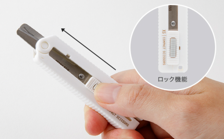 Hand with thumb on the lock mechanism with a close-up inset of the lock mechanism with text in Japanese.