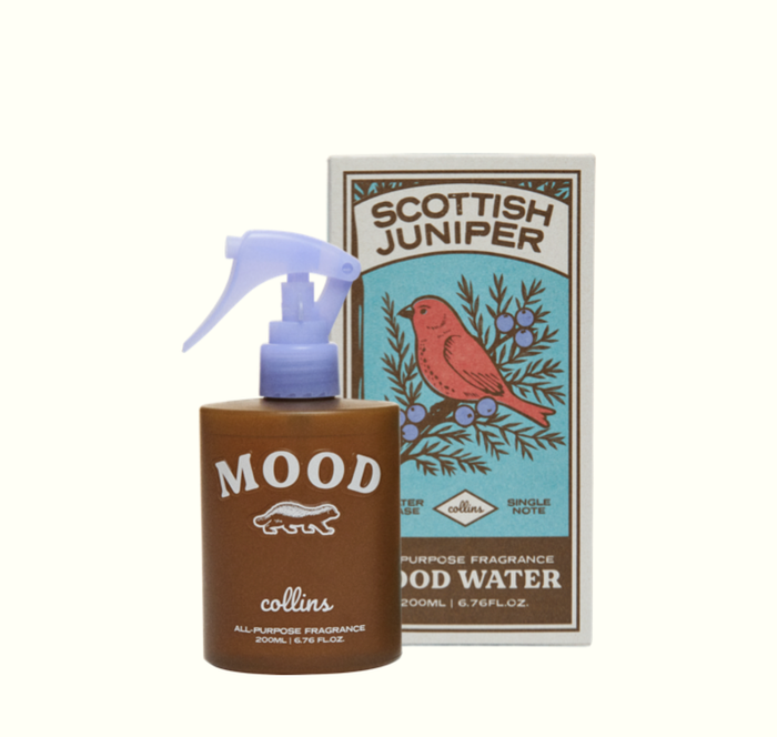 Brown bottle with a light blue pump and text, next to its box with an illustration of a red bird on a juniper branch.