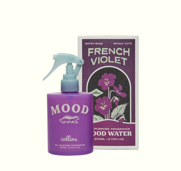 Purple bottle with a light blue pump and text, next to its box with an illustration of violets.