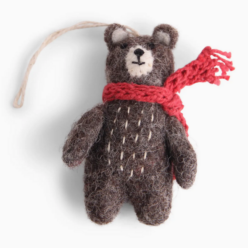 Small brown teddy bear with a red scarf on a white background