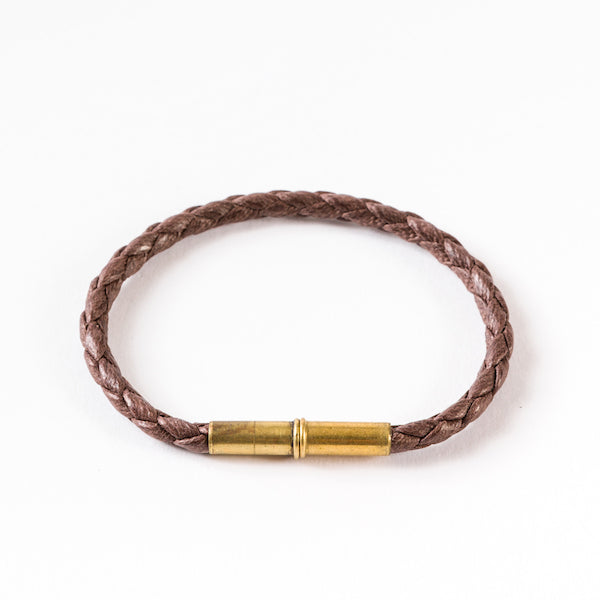 Brown braided bracelet with a brass cylindrical magnetic clasp.