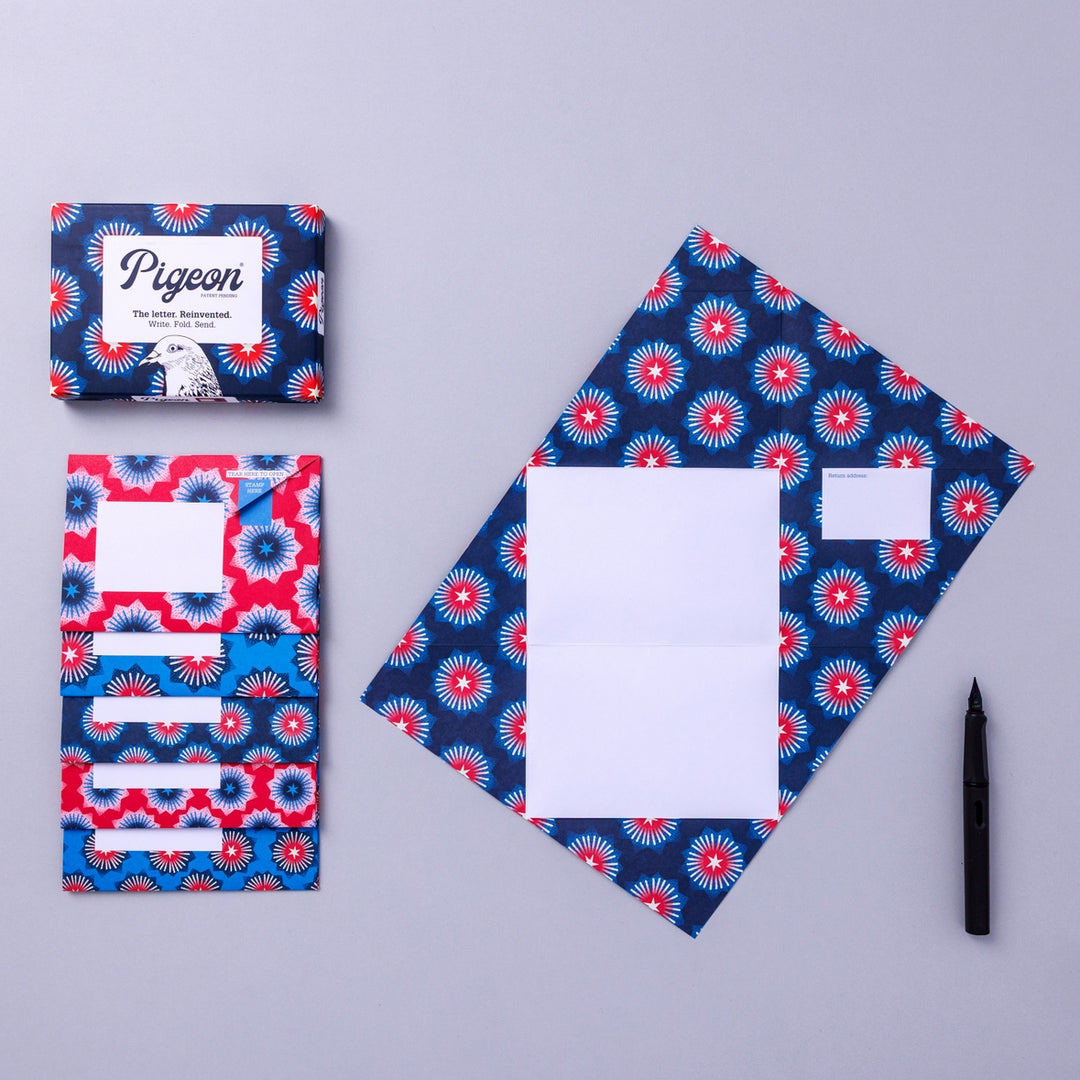 Writing set opened to show five envelopes, each with a different design, and the sixth unfolded to show the writing area, all decorated with starbursts.