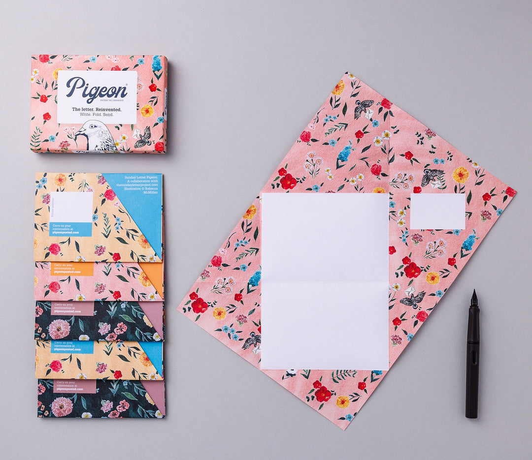 Writing set opened to show five envelopes, each with a different design, and the sixth unfolded to show the writing area, all decorated with colorful flowers.