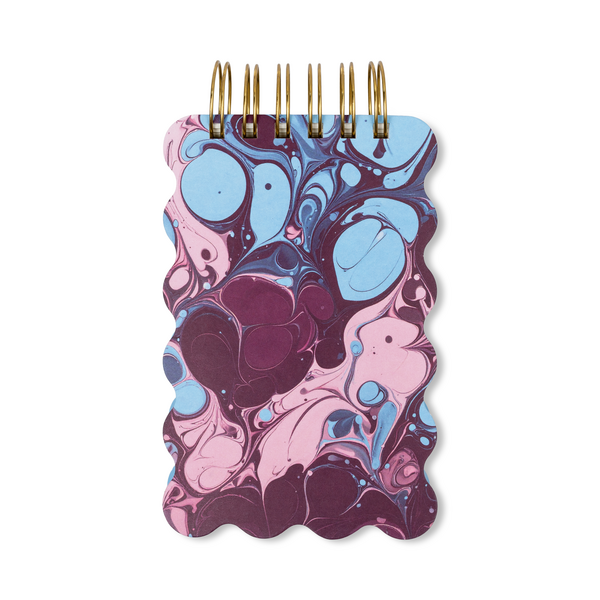 Notebook with pink and blue marbled cover and wavy edges.