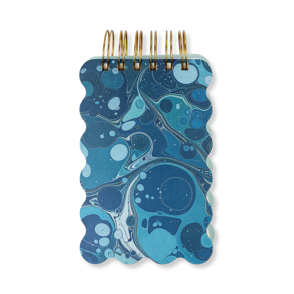 Notebook with blue marbled cover and wavy edges.