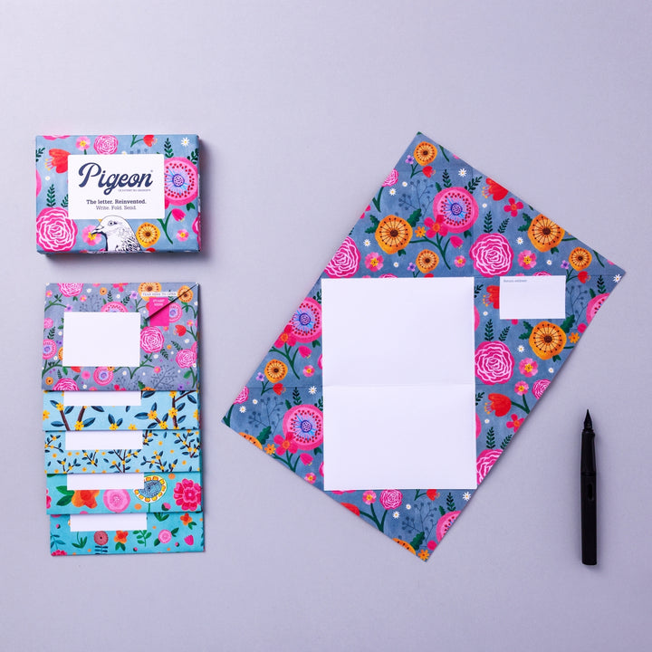 Writing set opened to show five envelopes, each with a different design, and the sixth unfolded to show the writing area, all decorated with bright flowers.