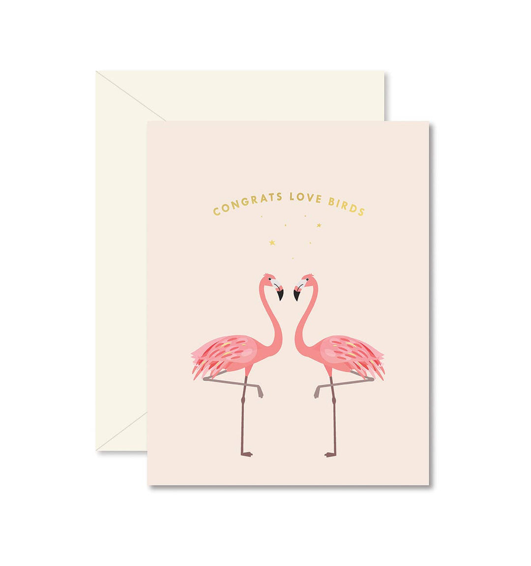 Two pink flamingos face each other under gold sans serif text