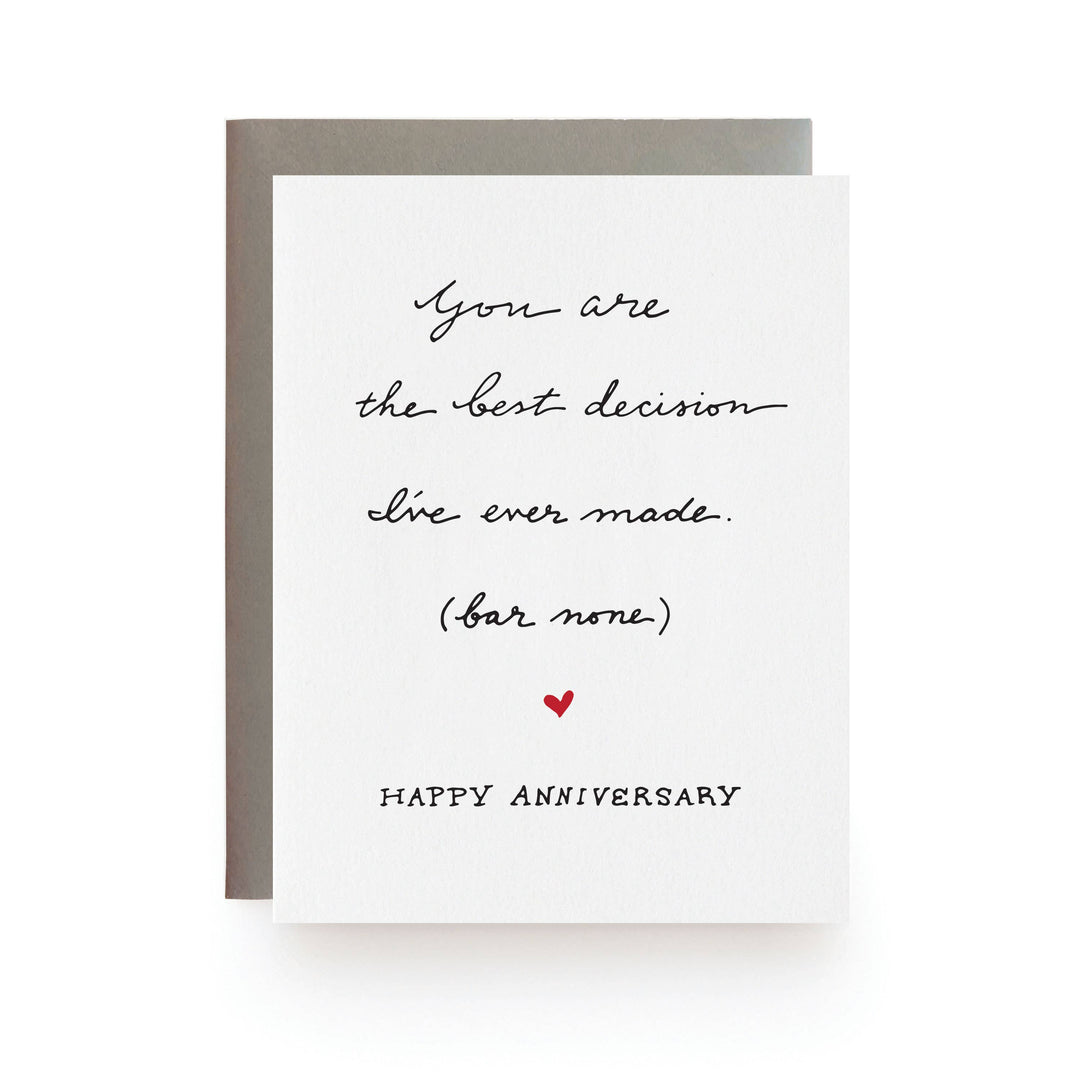 Black text in script over a small red heart on white cardstock.