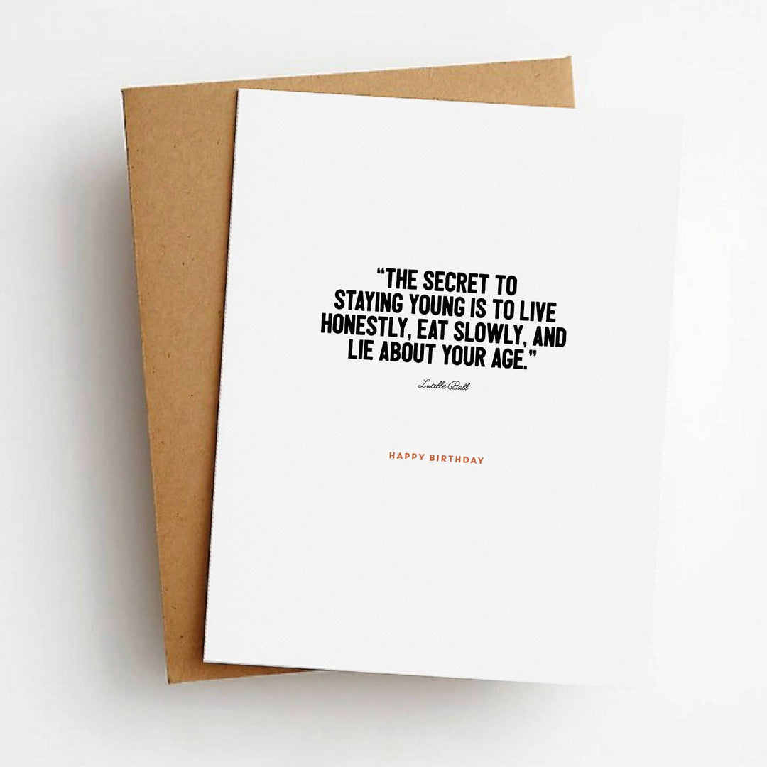 Front of birthday card with quote from Lucille Ball in black text on a white background over the text "Happy Birthday" in red.