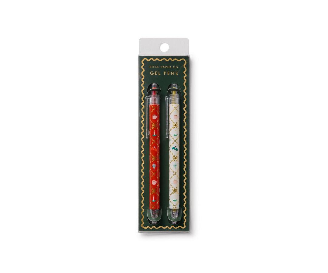 Two pens in packaging, the red with illustrations on the left, and the white with different illustrations on the right.