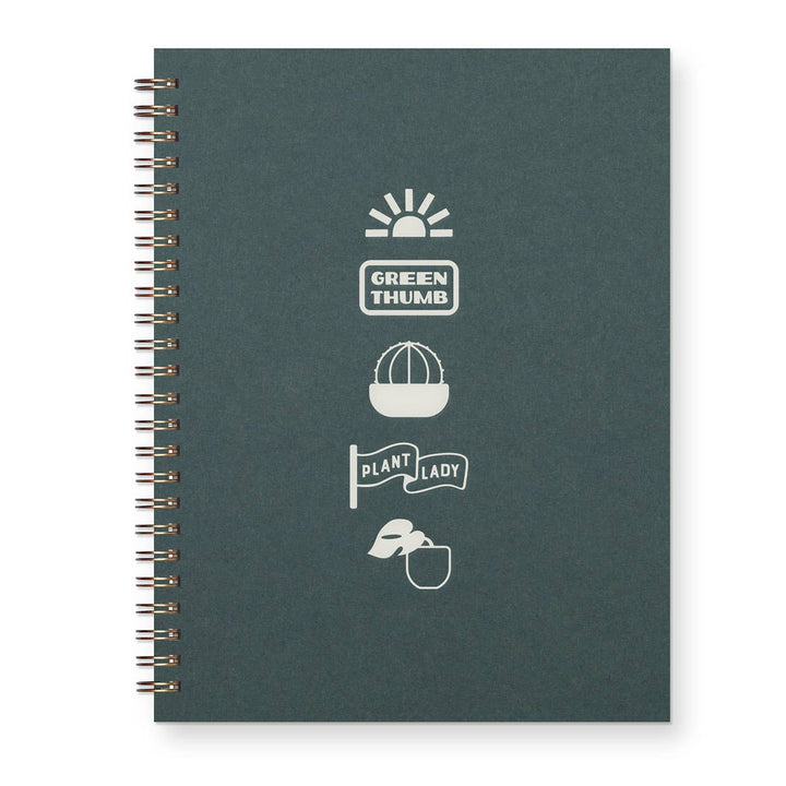 Spiral-bound journal with forest green cover and various glyphs and text on front.