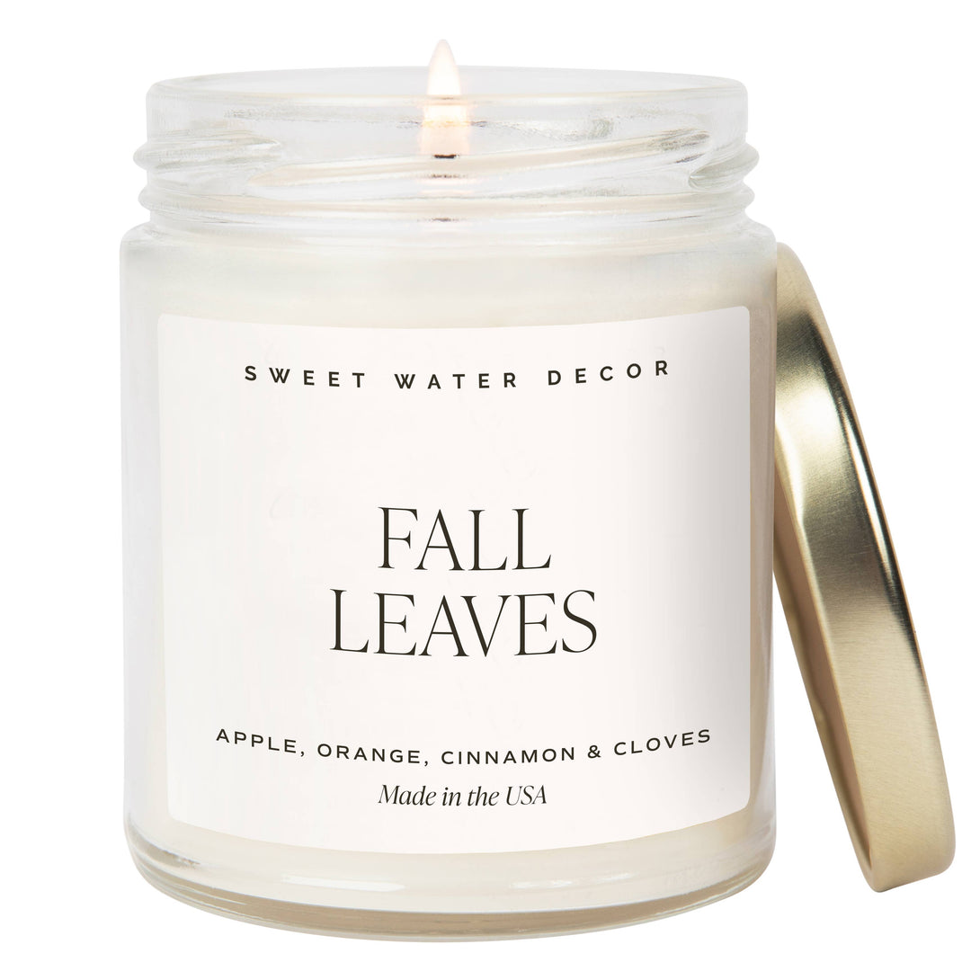 Scented soy candle in a clear glass container with lid. Fall leaves: Apple, Orange, Cinnamon and Cloves.