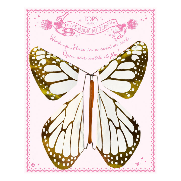 Butterfly-shaped object with gold and white wings on a pink and white card.