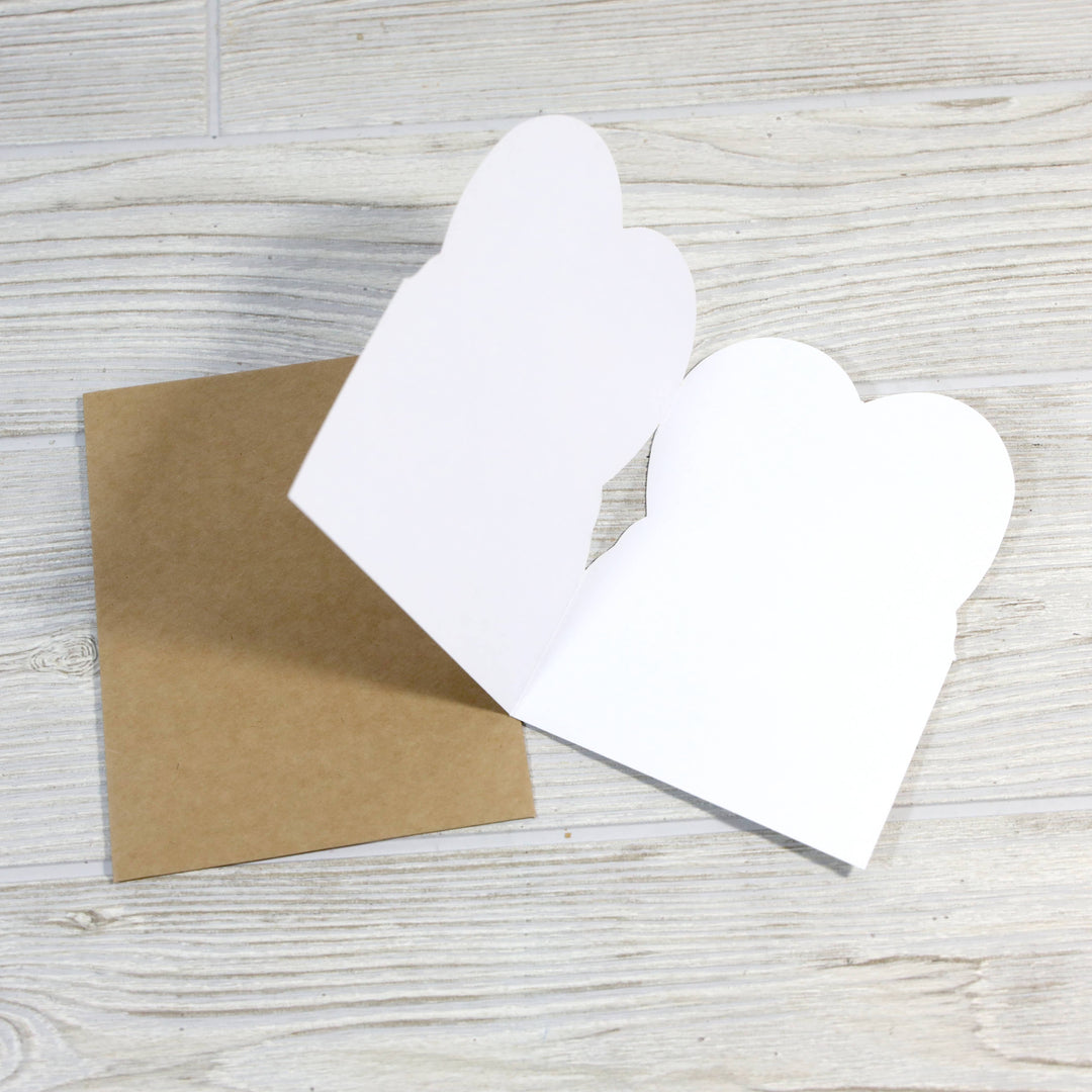 Inside of the card, open to show the die-cut heart shape, next to the kraft envelope.