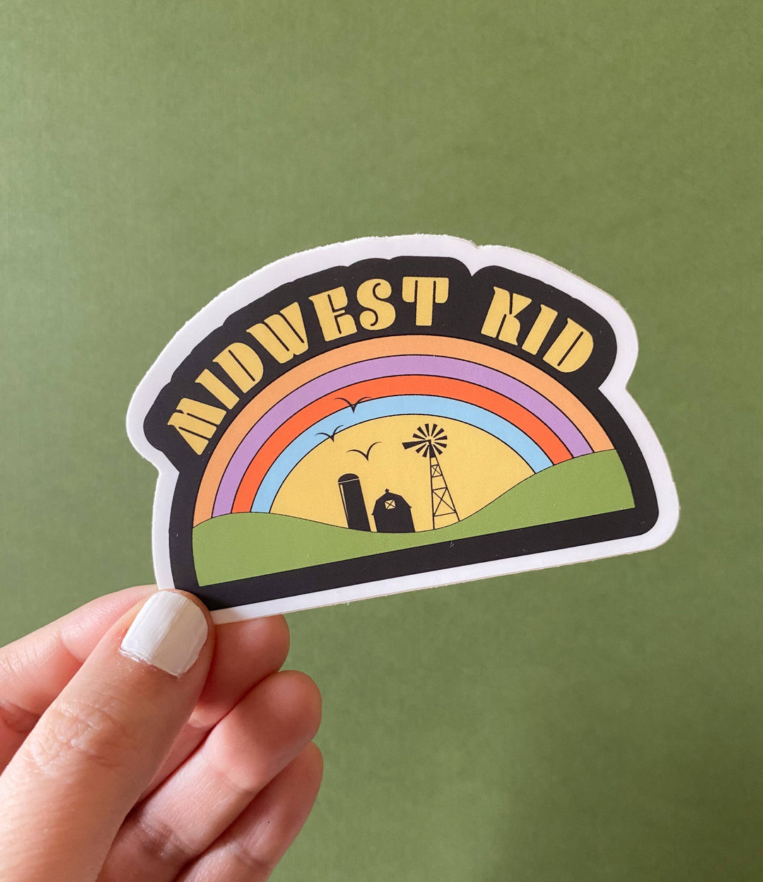 'Midwest Kid' text above a graphic depicting a rainbow over farm  structures.