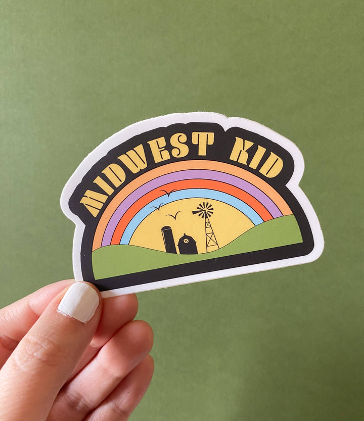 'Midwest Kid' text above a graphic depicting a rainbow over farm  structures.